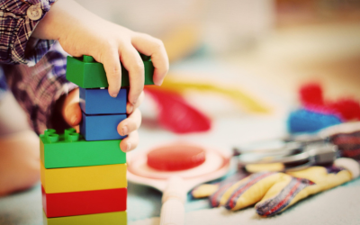 Kinderhände mit bunten Duplo Steinen und anderen Spielzeugen - freies Spiel